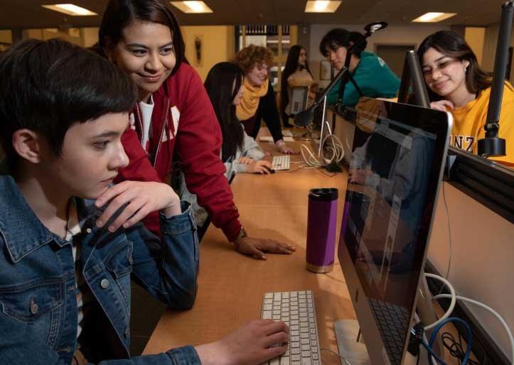 students and staff work together at computers