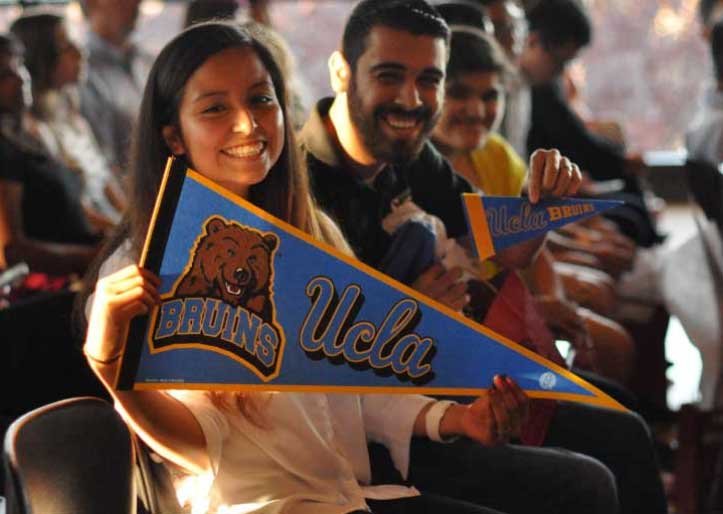 student holding UCLA pennant