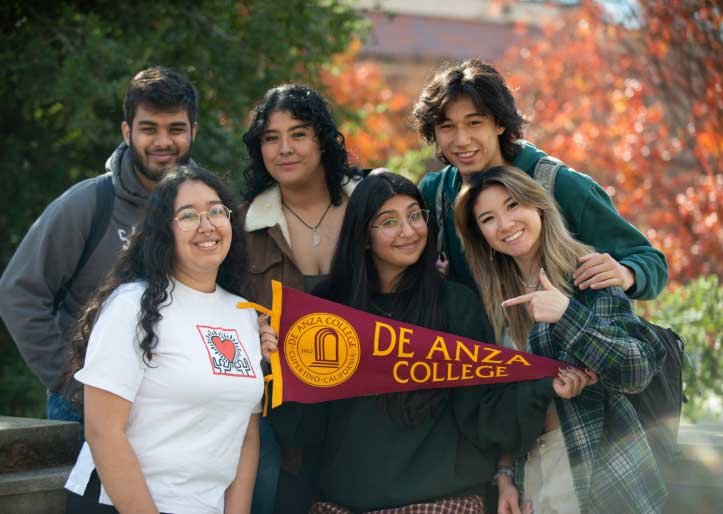 students holding De Anza pennant